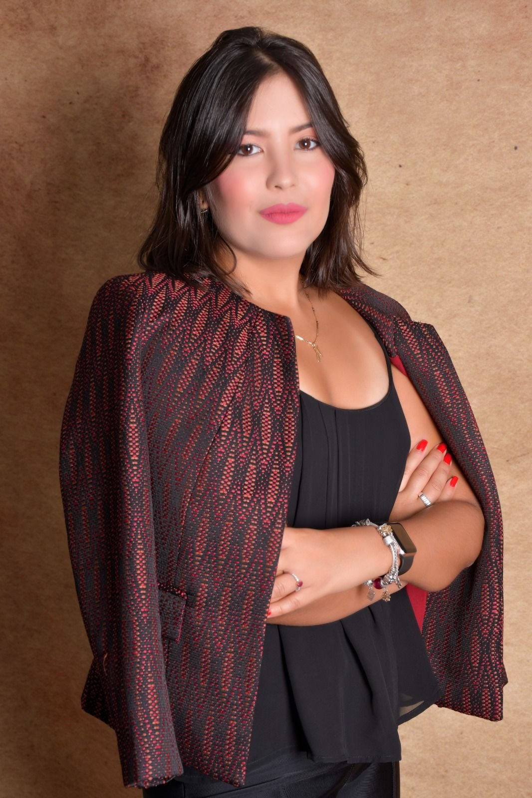 Natalia Rodrigues Lopes, advogada, de braços cruzados e blazer bordô